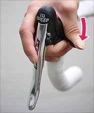 カンパニョーロは、レバーだけでなくブラケット内側に付いているボタンも使う。この右側ボタンを親指で下に押すと後ろのギアが重くなる（シフトアップ）